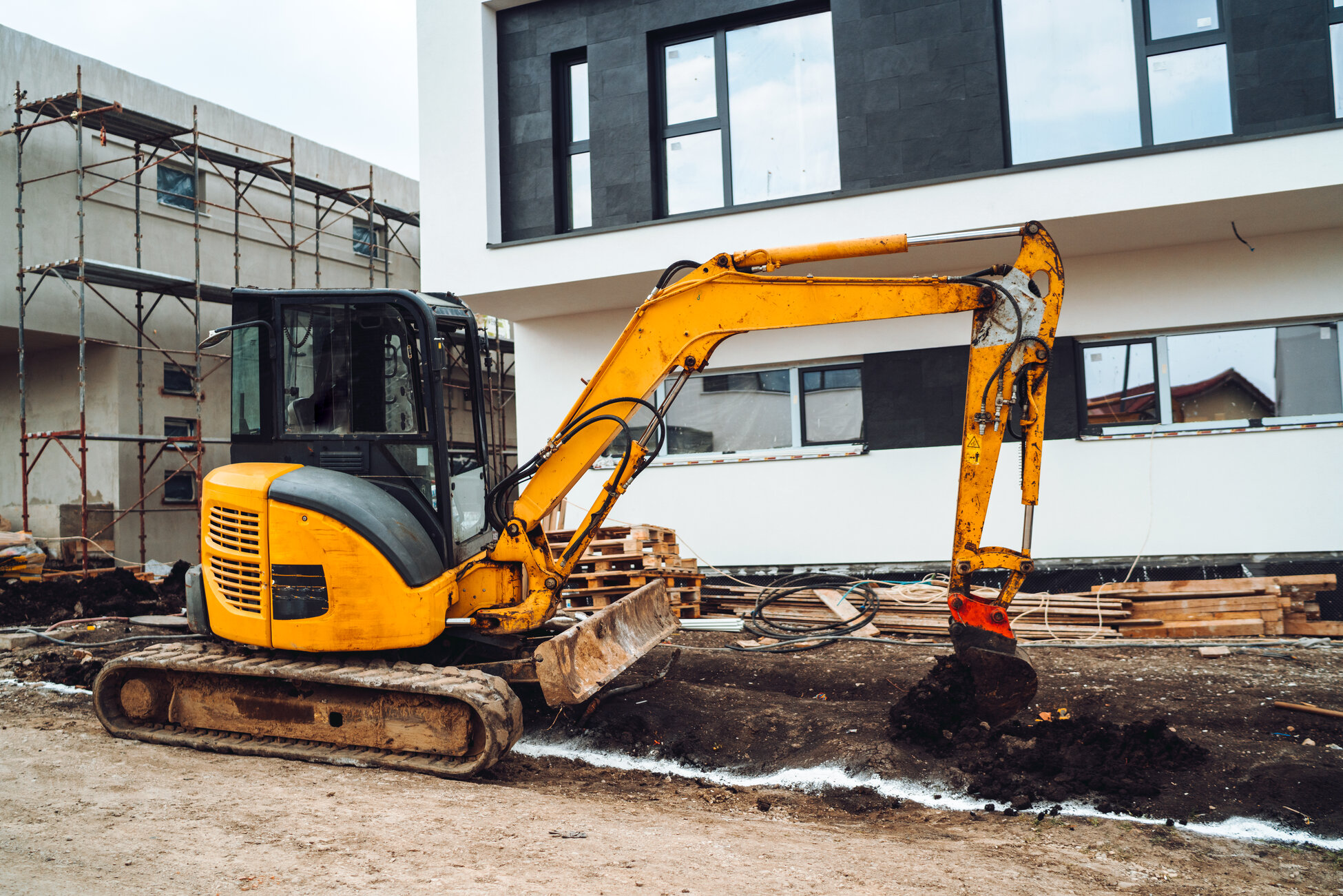 Mini heavy duty excavator moving earth for foundation building. Industrial machinery on construction site, renta de maquinaria